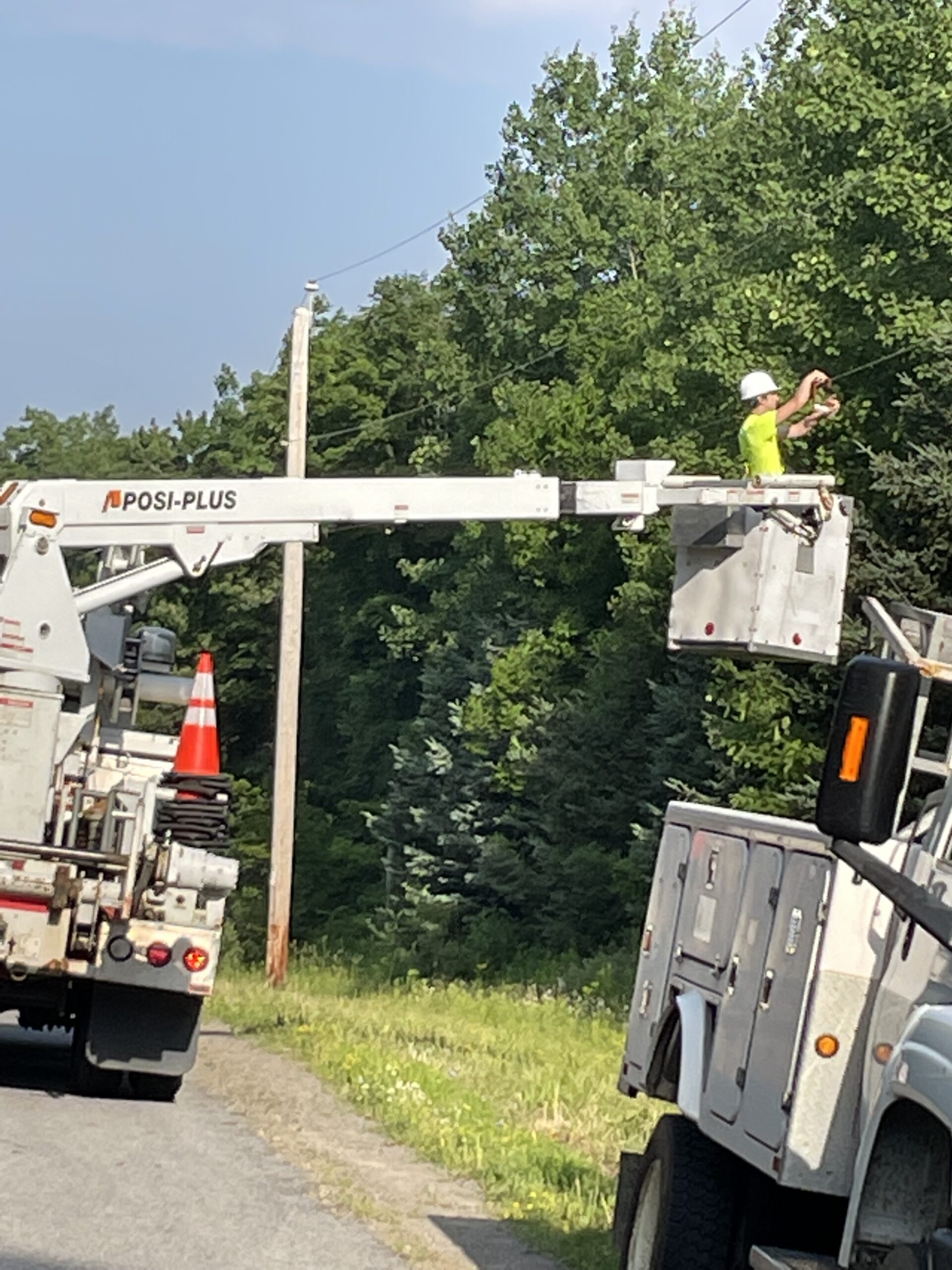 TermLink Solutions crew performing aerial fiber installation using a bucket truck along a rural roadside