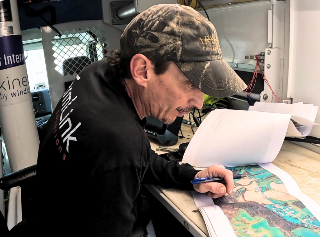 TermLink Solutions team member reviewing fiber route maps and field plans during pre-construction survey.