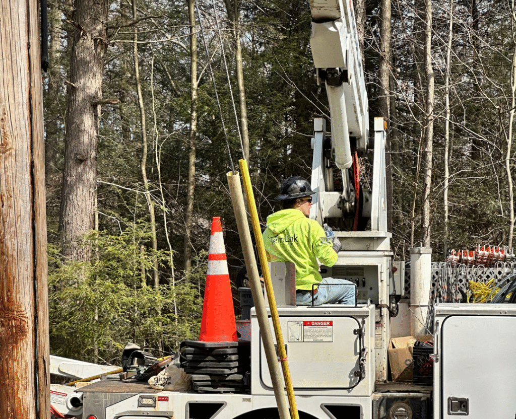 Lineman adjusting equipment during high-temperature summer install
