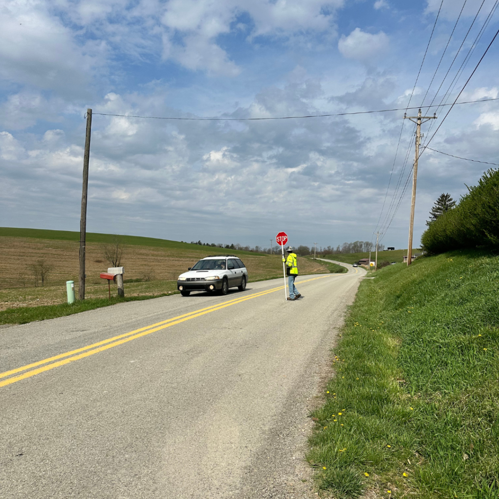 Roadside fiber installation site with traffic cones, signage, and proper vehicle visibility