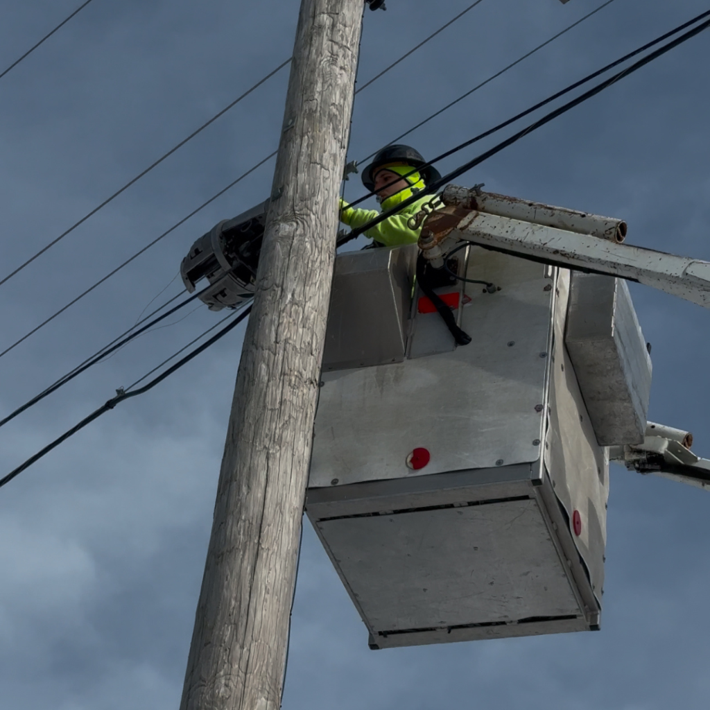Utility worker installing aerial fiber for smart grid connectivity