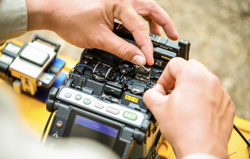 Technician securing and testing fiber installations to protect critical infrastructure.